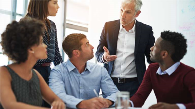 Picture of diverse group of co-workers sitting around a table talking.